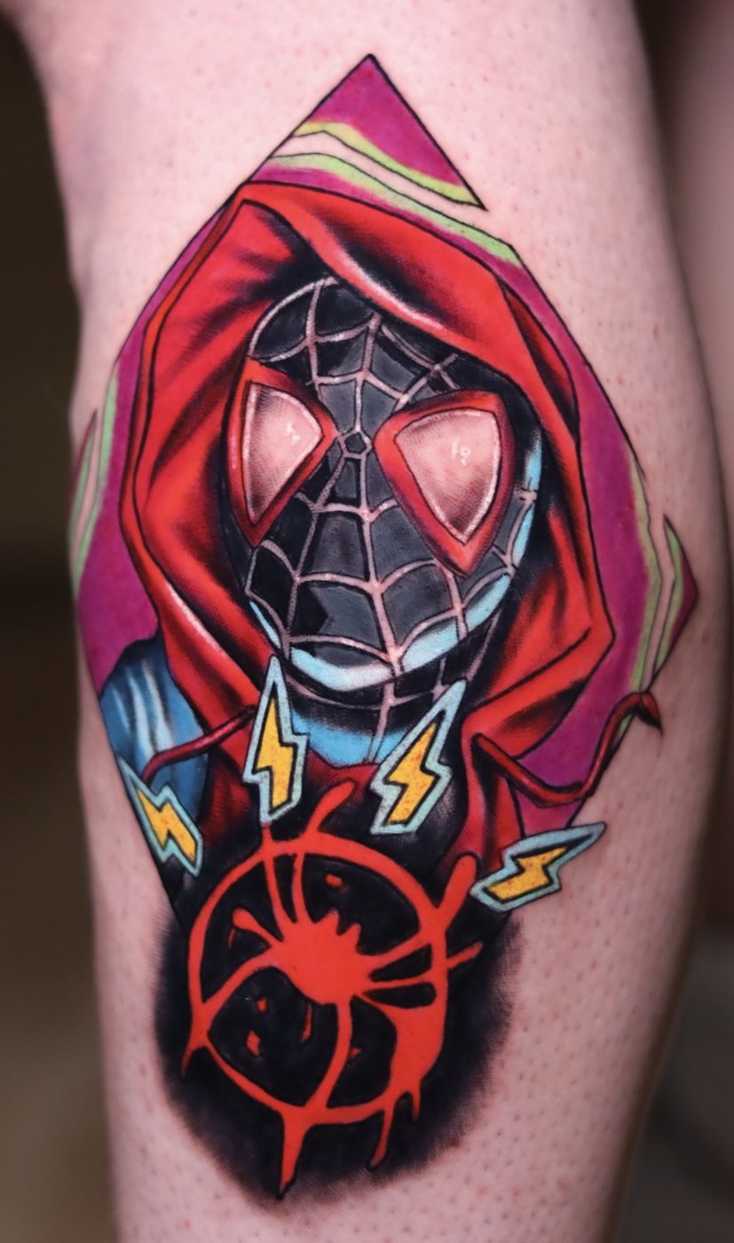 Tatuaje a color de un personaje de cómic con capucha roja